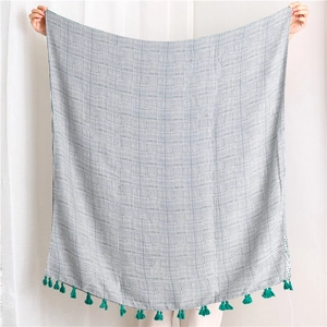 Detailed texture of houndstooth linen scarf featuring vibrant green cotton tassels