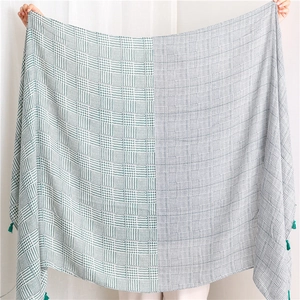 Green houndstooth cotton linen shawl with tassels shown fully unfolded on a white background