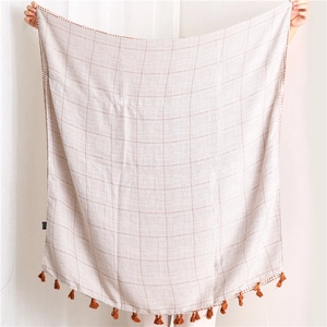 Detail of a lightweight houndstooth cotton linen scarf with elegant fringe tassels