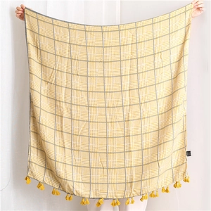 Detail of yellow and white houndstooth shawl with elegant fringe tassels and soft texture