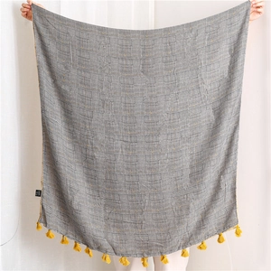 Close-up of black and white houndstooth cotton linen scarf with bright yellow tassels