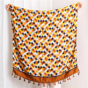 Detail of colorful plaid cotton linen scarf featuring vibrant weave and fringe tassels