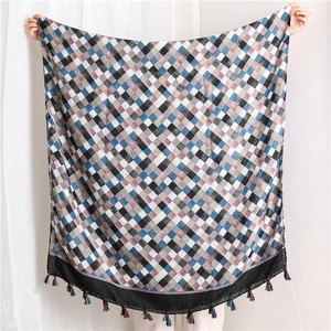 Detail of multi-color plaid cotton linen scarf featuring delicate fringe edge and woven texture