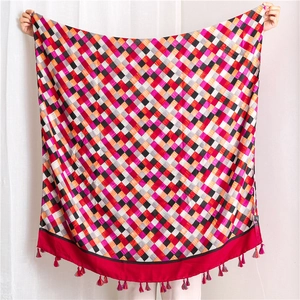 Detail of vibrant colorful checkered cotton linen scarf with red tassel trim