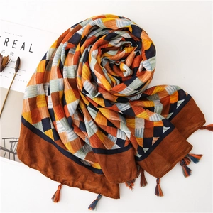 Close-up of checkered cotton scarf with vibrant colorful tassels and woven texture
