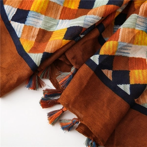 Detail of woven plaid scarf featuring colorful tassels and textured cotton linen fabric