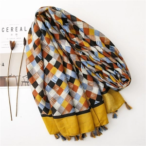 Detail of plaid cotton linen scarf with woven tassels and warm yellow border trim