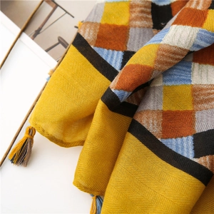 Detail of yellow checkered cotton linen scarf featuring herringbone weave and tassels