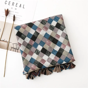 Detail of checkered cotton linen scarf featuring colorful fringe and artistic texture