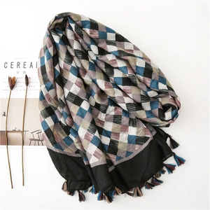Detail of woven plaid cotton linen scarf featuring colorful tassels and soft texture