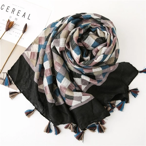Close-up of woven plaid scarf with colorful tassels and soft cotton linen texture