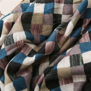 Detailed close-up of woven cotton-linen scarf showing blue plaid pattern and twill texture
