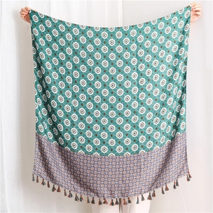 Detail of dark green bohemian cotton scarf featuring geometric print and tassel fringe