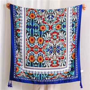 Detailed view of dark blue square scarf featuring ethnic geometric floral print and tassels
