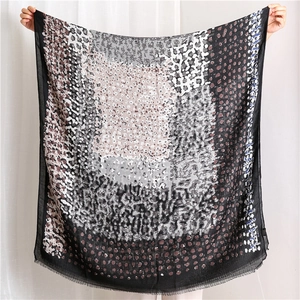Detail view of abstract leopard print linen scarf showing soft fringe edges and texture