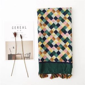 Detail of colorful plaid cotton linen scarf with fringe tassels and soft weave texture