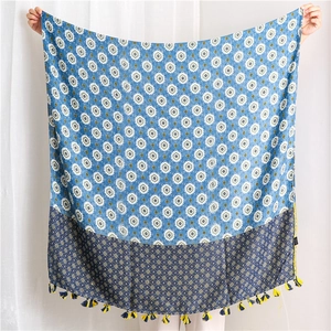 Detail of blue lotus pattern cotton scarf with vibrant blue and yellow contrast tassels