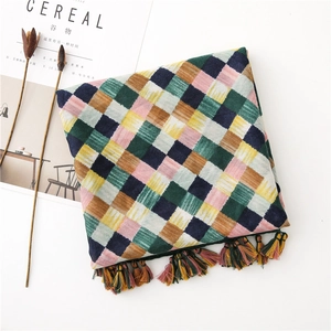 Detail of colorful plaid cotton linen scarf with handmade fringe and retro weave texture