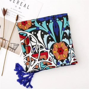 Close-up of bohemian pattern scarf with deep blue tassels and floral geometric print