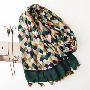 Detail of colorful plaid cotton linen scarf with soft fringe trim and vibrant woven pattern