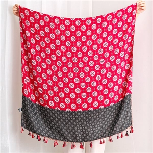 Detailed view of red bohemian cotton scarf with geometric star patterns and tassel trim