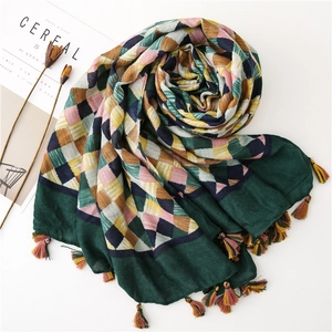 Detail of colorful woven checkered scarf featuring handmade tassels on white background