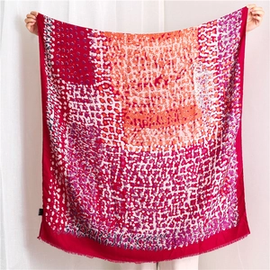 Detail of artistic oil painting style linen shawl with red geometric patterns and frayed edges