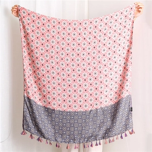 Detail of pink and grey lotus print scarf with decorative tassels and geometric patterns
