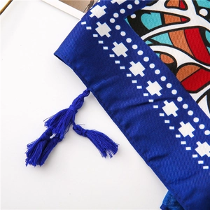 Macro detail of royal blue ethnic print shawl featuring decorative fringe and twill texture