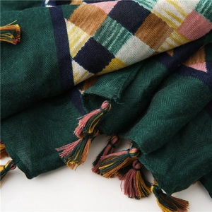 Close-up of deep green checkered cotton linen scarf with colorful fringe detail