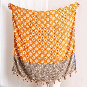 Detail of bohemian cotton lotus scarf with orange floral prints and tassel fringe edges
