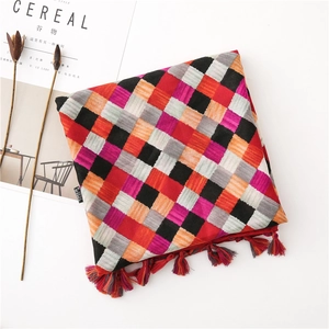 Detailed texture of checkered cotton scarf with colorful tassels and artistic props