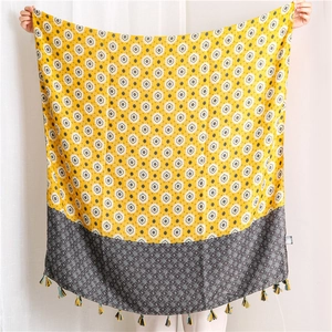 Detail of bohemian floral print scarf in yellow and grey with fine fringe edges