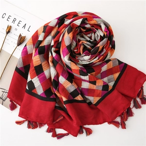 Detail of colorful plaid cotton linen scarf with frayed fringe edges and woven texture