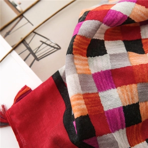 Detailed close-up of herringbone weave cotton linen scarf with colorful plaid and red fringe
