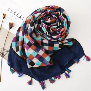 Detail of checkered cotton linen scarf with colorful tassels and soft woven texture