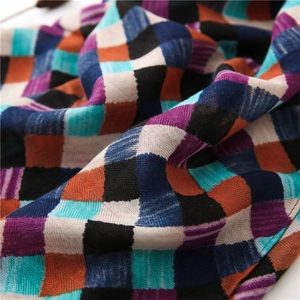 Close-up of woven cotton linen scarf showing multi-color plaid texture and soft fabric detail