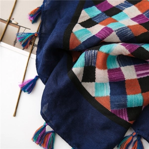 Macro detail of plaid cotton linen scarf with colorful geometric patterns and tassels