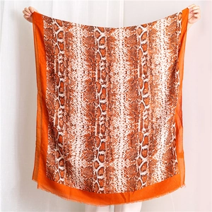 Orange and white snakeskin print scarf with fringed edges and lightweight texture