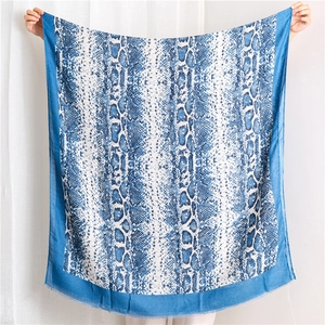 Large blue and white snake print silk scarf held open to show full texture and pattern