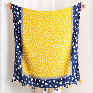 Détail de la texture d'une écharpe en coton et lin à pois avec des glands