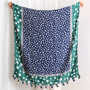 Texture détaillée d'une écharpe en coton avec motif à pois bleu marine et franges