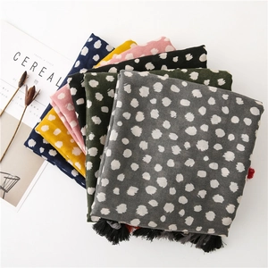 Vue à plat détaillée de foulards à pois et glands en couleurs variées avec texture coton