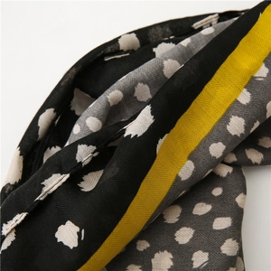 Gros plan d'une écharpe en coton avec motif chevrons et imprimé léopard jaune et noir