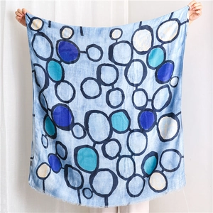 Détail d'écharpe en coton lin bleu clair avec motifs cercles et bordures à franges