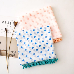 Polka dot scarf set in pink and blue with decorative pom-poms on a white background