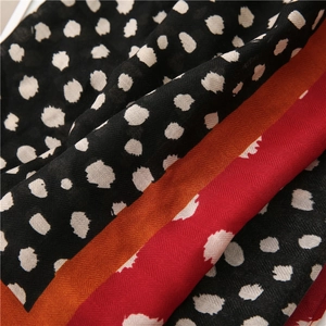 Vue détaillée d'une écharpe léopard avec rayures orange et tissu en sergé de haute qualité