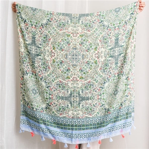 Close-up of green and blue floral bohemian cotton scarf with woven tassel fringes