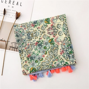 Close-up of cotton linen scarf with floral print and colorful tassel decorations