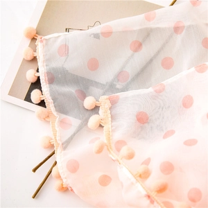 Detail of pink polka dot sheer scarf with matching soft pom-poms on the edges